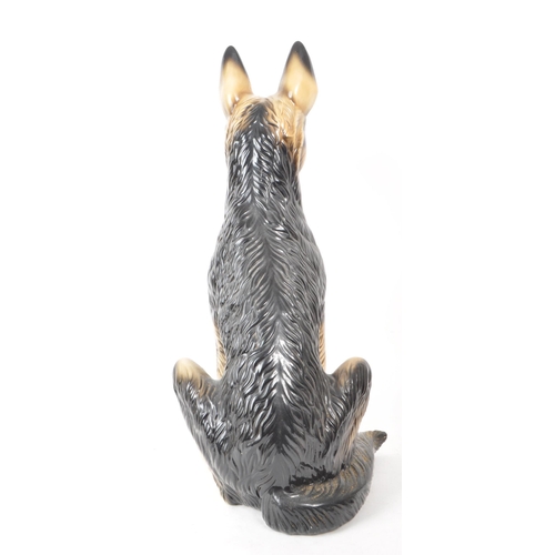 191 - A 20th century vintage porcelain German Shepherd figurine. The figurine being modelled panting in se... 