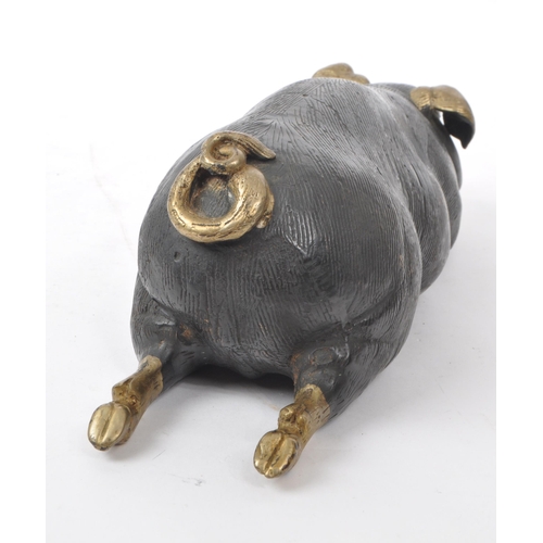 201 - A vintage 20th-century bronze figure of a pig lying down, with gilt detailing to the feet, nose, tai... 