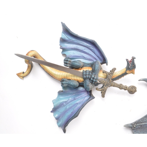 206 - Two contemporary resin dragon wall-hanging figures, including a dark blue painted dragon with its wi... 