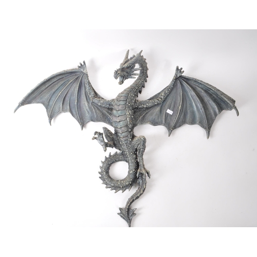 206 - Two contemporary resin dragon wall-hanging figures, including a dark blue painted dragon with its wi... 