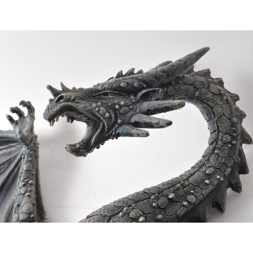 206 - Two contemporary resin dragon wall-hanging figures, including a dark blue painted dragon with its wi... 