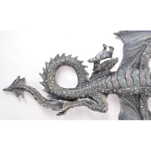 206 - Two contemporary resin dragon wall-hanging figures, including a dark blue painted dragon with its wi... 