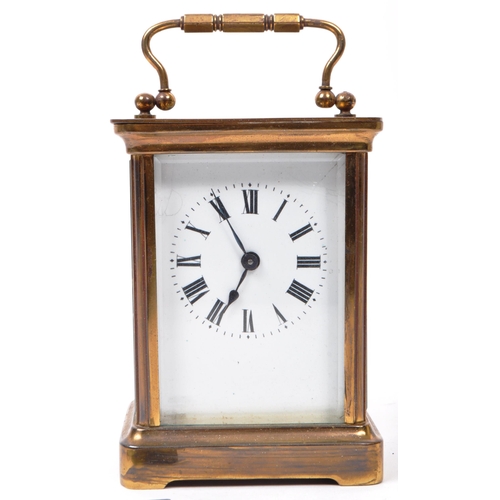 212 - An early 20th-century carriage clock, with a brass case and handle, glass beveled sides, and a see-t... 