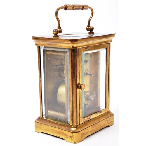 212 - An early 20th-century carriage clock, with a brass case and handle, glass beveled sides, and a see-t... 