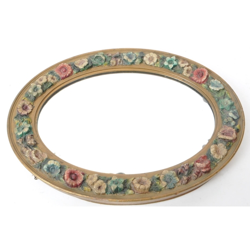 219 - An early 20th century circa 1930s barbola mirror. The mirror of oval form, with relief floral decora... 