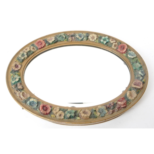 219 - An early 20th century circa 1930s barbola mirror. The mirror of oval form, with relief floral decora... 