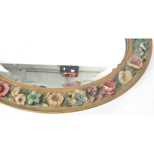 219 - An early 20th century circa 1930s barbola mirror. The mirror of oval form, with relief floral decora... 