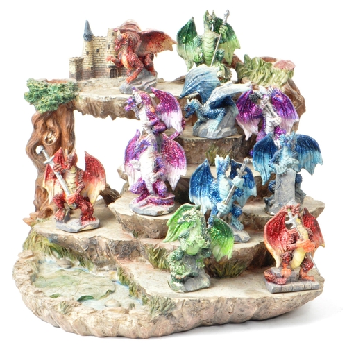 234 - A collection of three contemporary resin stands housed with dragon figures, comprising of a mountain... 