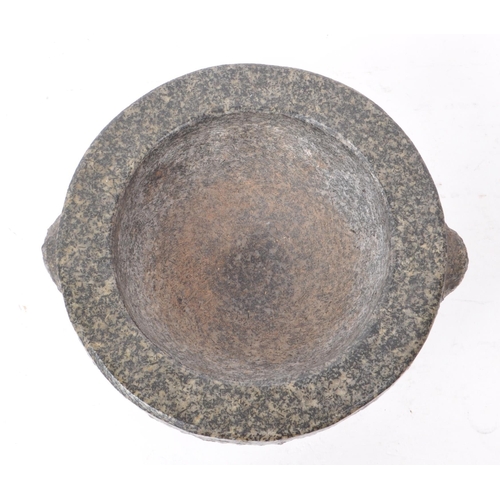 238 - A 20th-century large granite molcajete / pestle and mortar, with two stump handles and a flared base... 