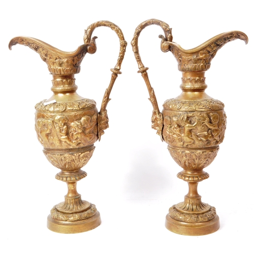 270 - Two vintage 20th-century brass repoussé ewers, ornately decorated in cherub figures, grapes, leaves,... 