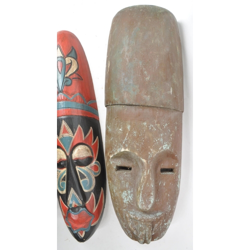 273 - A collection of three 20th century tribal African carved wooden pieces, consisting of two carved mas... 