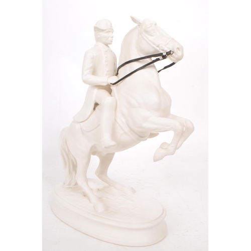 28 - A vintage 20th century white porcelain man riding a horse figure, featuring attached leather straps ... 