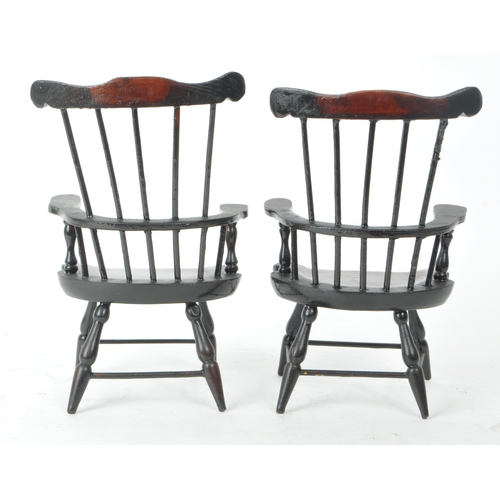 284 - A pair of 20th century paper mache combe back windsor chairs. The chairs having shaped top rail with... 