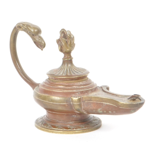 304 - A 19th century Victorian bronze oil lamp, with a dragon shaped looping handle and carved lid that li... 