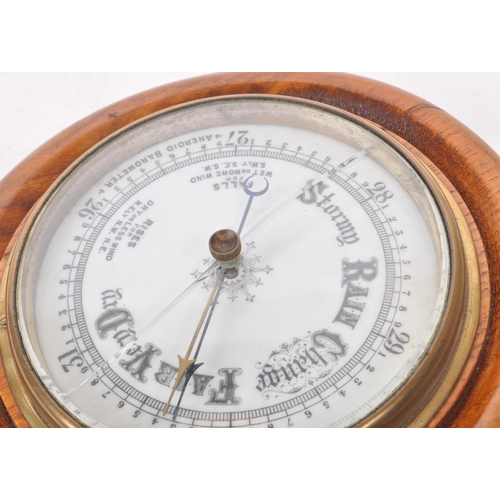 376 - A late 19th century Victorian aneroid barometer, mounted on an oak plinth base, with brass mounts an... 