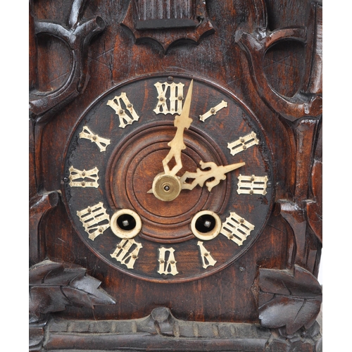 378 - An early 20th century carved wooden mantel cuckoo clock, in the style of black forest. Featuring an ... 