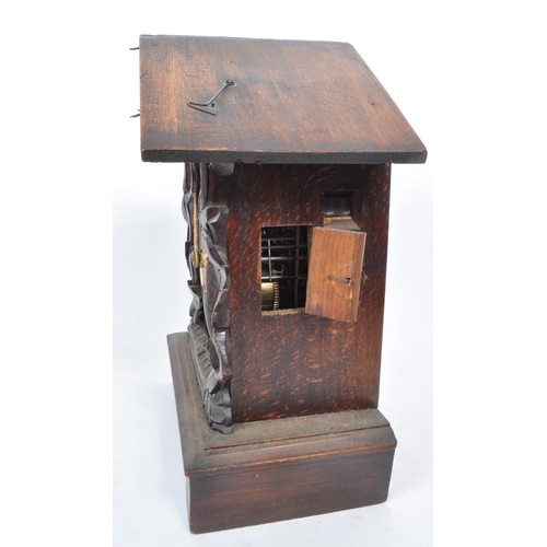 378 - An early 20th century carved wooden mantel cuckoo clock, in the style of black forest. Featuring an ... 