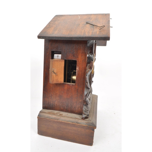 378 - An early 20th century carved wooden mantel cuckoo clock, in the style of black forest. Featuring an ... 