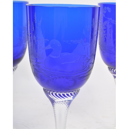 387 - A collection of mid century cobalt blue hand blown glasses / goblets. Featuring etched birds on the ... 