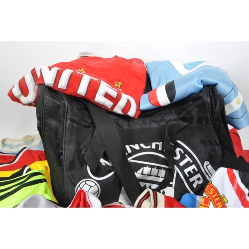 394 - A collection of 21st century Manchester United football shirts and two kit bags, including fan shirt... 