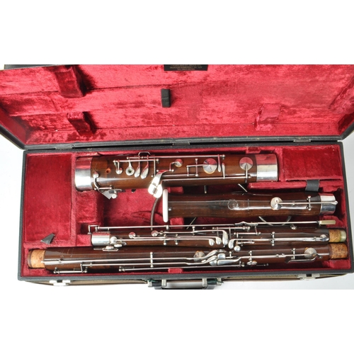 426 - G. H. Hüller Schöneck - An early 20th century German Bassoon with metal mounts, no.56494. Housed wit... 