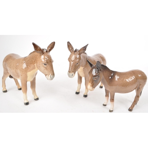 46 - Beswick - Three 20th century china donkey figurines, including two adult standing donkeys and a stan... 