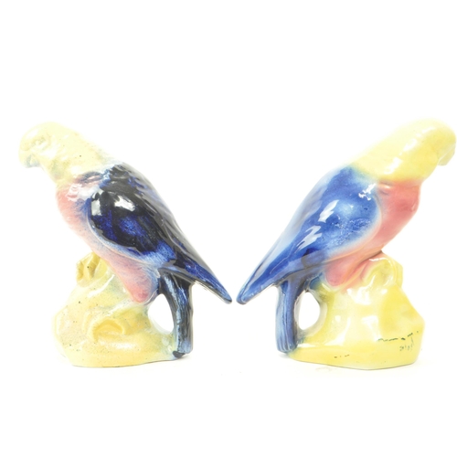 467 - A pair of 19th century Victorian ceramic bird parrot figurines, with a yellow, pink and blue glaze. ... 