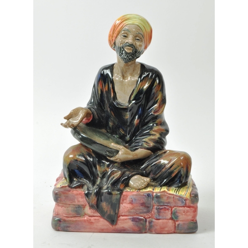 59 - Royal Doulton - A mid-century glazed porcelain sitting beggar figure no. HN 1365 'Mendicant', design... 