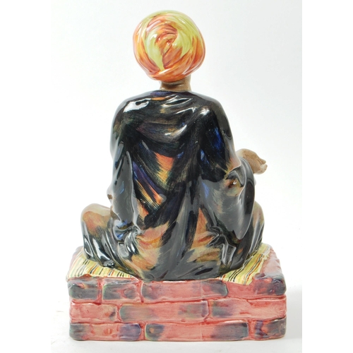 59 - Royal Doulton - A mid-century glazed porcelain sitting beggar figure no. HN 1365 'Mendicant', design... 