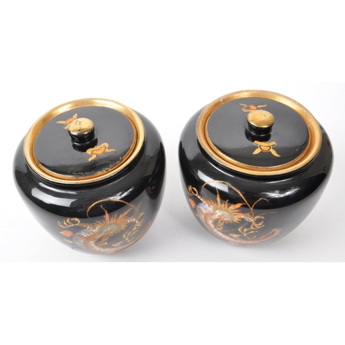 76 - Crown Devon - Fieldings - Two early 20th-century ceramic lidded tobacco jars / pots, with a black co... 