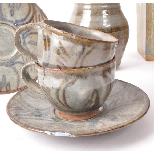 93 - A collection of contemporary studio pottery stoneware pieces, comprising of four cups, four saucers,... 