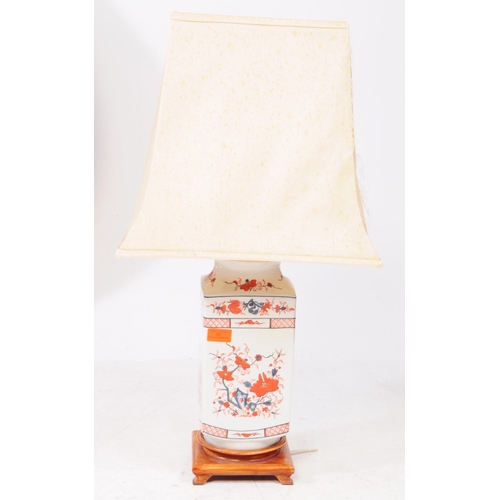 488 - An early 20th century Chinese ceramic imari style lamp, raised on a wooden structure with four short... 