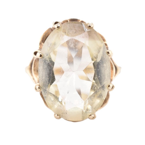 101 - A hallmarked 9ct gold and citrine cocktail ring. The 9ct yellow gold ring having a single oval cut c... 