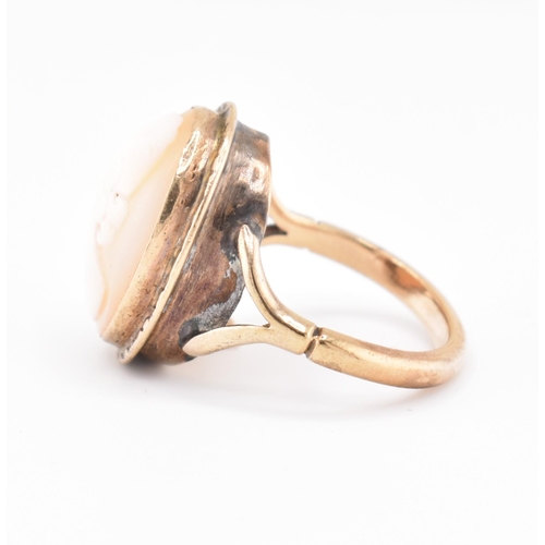 105 - A gold mounted cameo ring. The ring having a bezel set oval carved cameo to bifurcated shoulders and... 