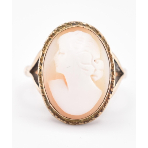 105 - A gold mounted cameo ring. The ring having a bezel set oval carved cameo to bifurcated shoulders and... 