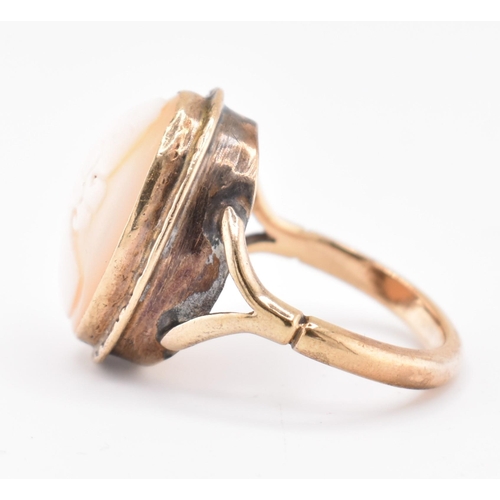 105 - A gold mounted cameo ring. The ring having a bezel set oval carved cameo to bifurcated shoulders and... 