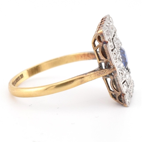 107 - An Art Deco sapphire and diamond panel ring. The ring is set with a central round cut sapphire, fram... 