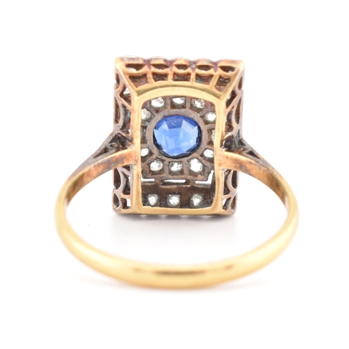 107 - An Art Deco sapphire and diamond panel ring. The ring is set with a central round cut sapphire, fram... 