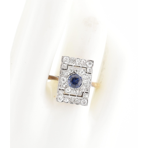 107 - An Art Deco sapphire and diamond panel ring. The ring is set with a central round cut sapphire, fram... 