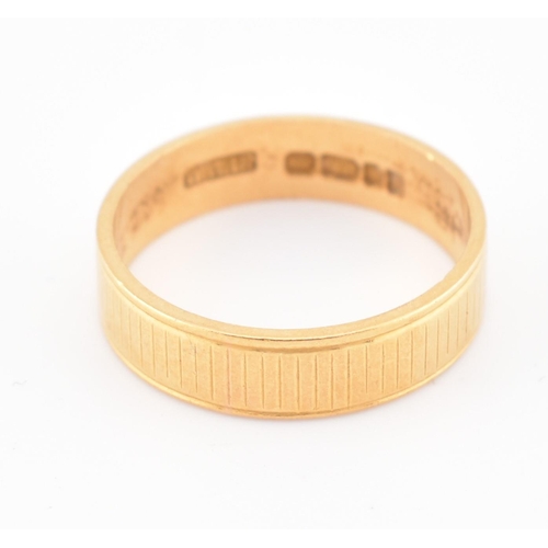 110 - A hallmarked 22ct gold band ring. The yellow gold band ring having an etched design. Hallmarked for ... 