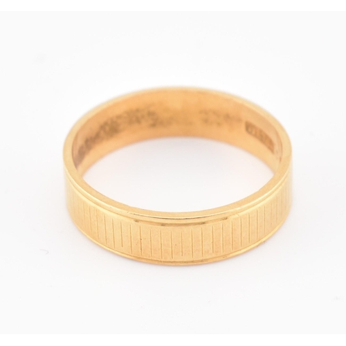 110 - A hallmarked 22ct gold band ring. The yellow gold band ring having an etched design. Hallmarked for ... 