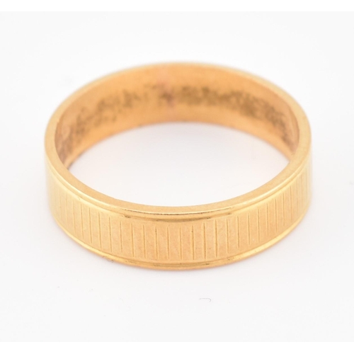 110 - A hallmarked 22ct gold band ring. The yellow gold band ring having an etched design. Hallmarked for ... 