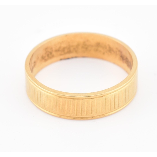 110 - A hallmarked 22ct gold band ring. The yellow gold band ring having an etched design. Hallmarked for ... 