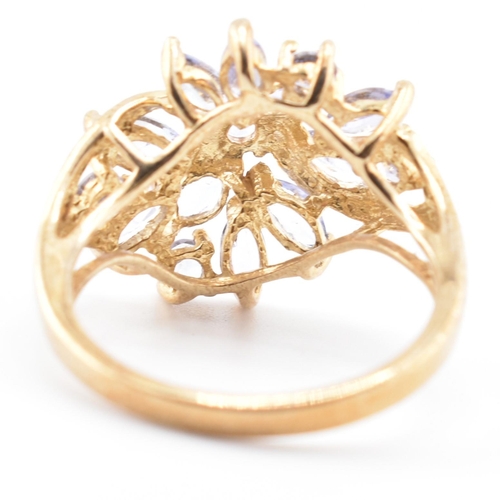 113 - A hallmarked 9ct gold and tanzanite cluster ring. The 9ct yellow gold ring having five round cut tan... 