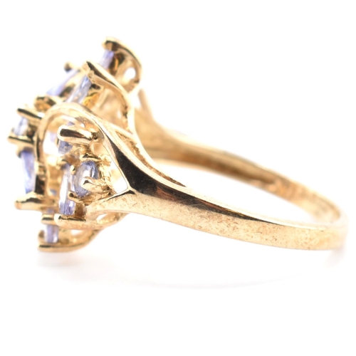 113 - A hallmarked 9ct gold and tanzanite cluster ring. The 9ct yellow gold ring having five round cut tan... 