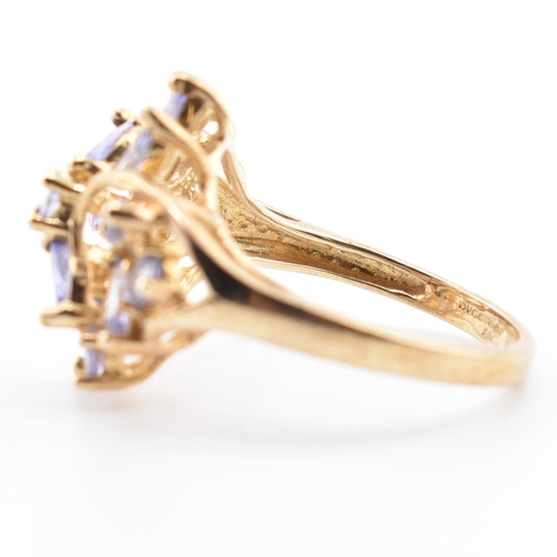 113 - A hallmarked 9ct gold and tanzanite cluster ring. The 9ct yellow gold ring having five round cut tan... 