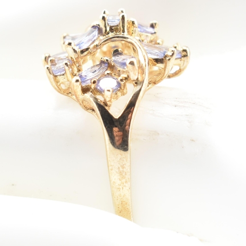 113 - A hallmarked 9ct gold and tanzanite cluster ring. The 9ct yellow gold ring having five round cut tan... 