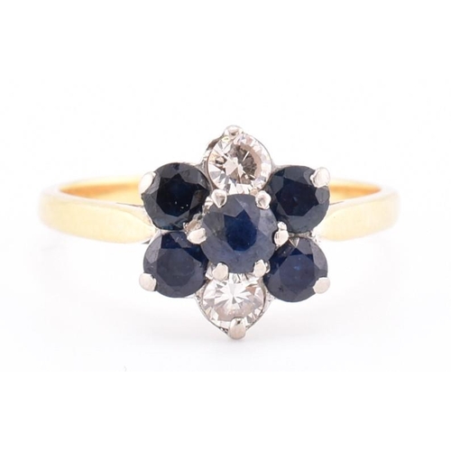 114 - An 18ct gold sapphire and diamond cluster ring. The 18ct yellow gold ring having a flower-shaped hea... 