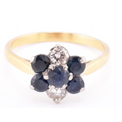 114 - An 18ct gold sapphire and diamond cluster ring. The 18ct yellow gold ring having a flower-shaped hea... 