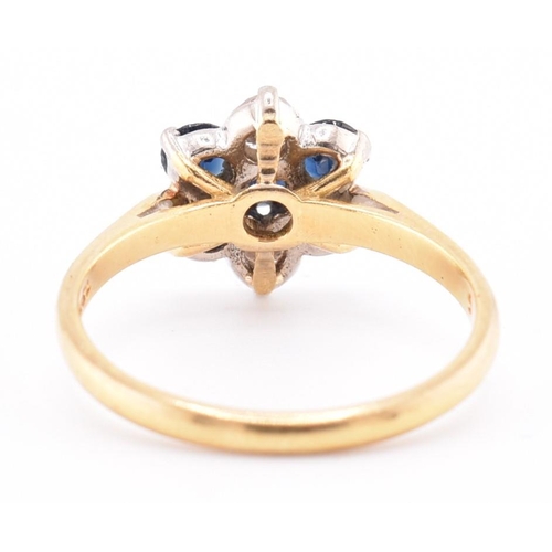 114 - An 18ct gold sapphire and diamond cluster ring. The 18ct yellow gold ring having a flower-shaped hea... 